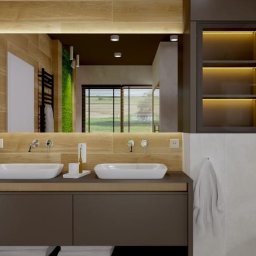 Tomasz Rogaczewski - Nowoczesna łazienka z dwoma białymi umywalkami nablatowymi, drewnopodobnymi płytkami na ścianie, dużym lustrem z podświetleniem LED i szafką pod umywalką w kolorze ciemnego brązu.