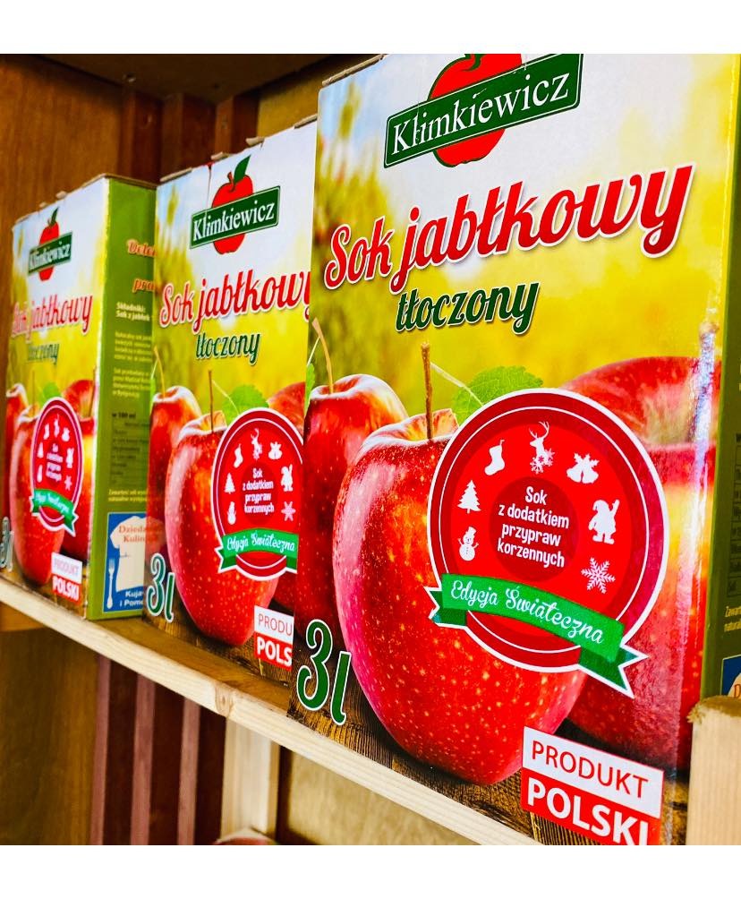 Półka z kartonami soku jabłkowego tłoczonego marki Klimkiewicz w edycji świątecznej z dodatkiem przypraw korzennych, produkt polski, opakowania 3 litrowe.