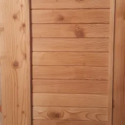 Detal drewnianej, surowej, nieobrobionej powierzchni z widocznymi słojami, potencjalnie przed piaskowaniem lub malowaniem proszkowym.