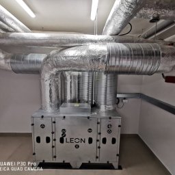 Instal-Went Baranowski Przemysław Psota Jarosław Spółka Cywilna - Centrala wentylacyjna LEON X z izolowanymi przewodami w pomieszczeniu technicznym, widoczna instalacja elektryczna.