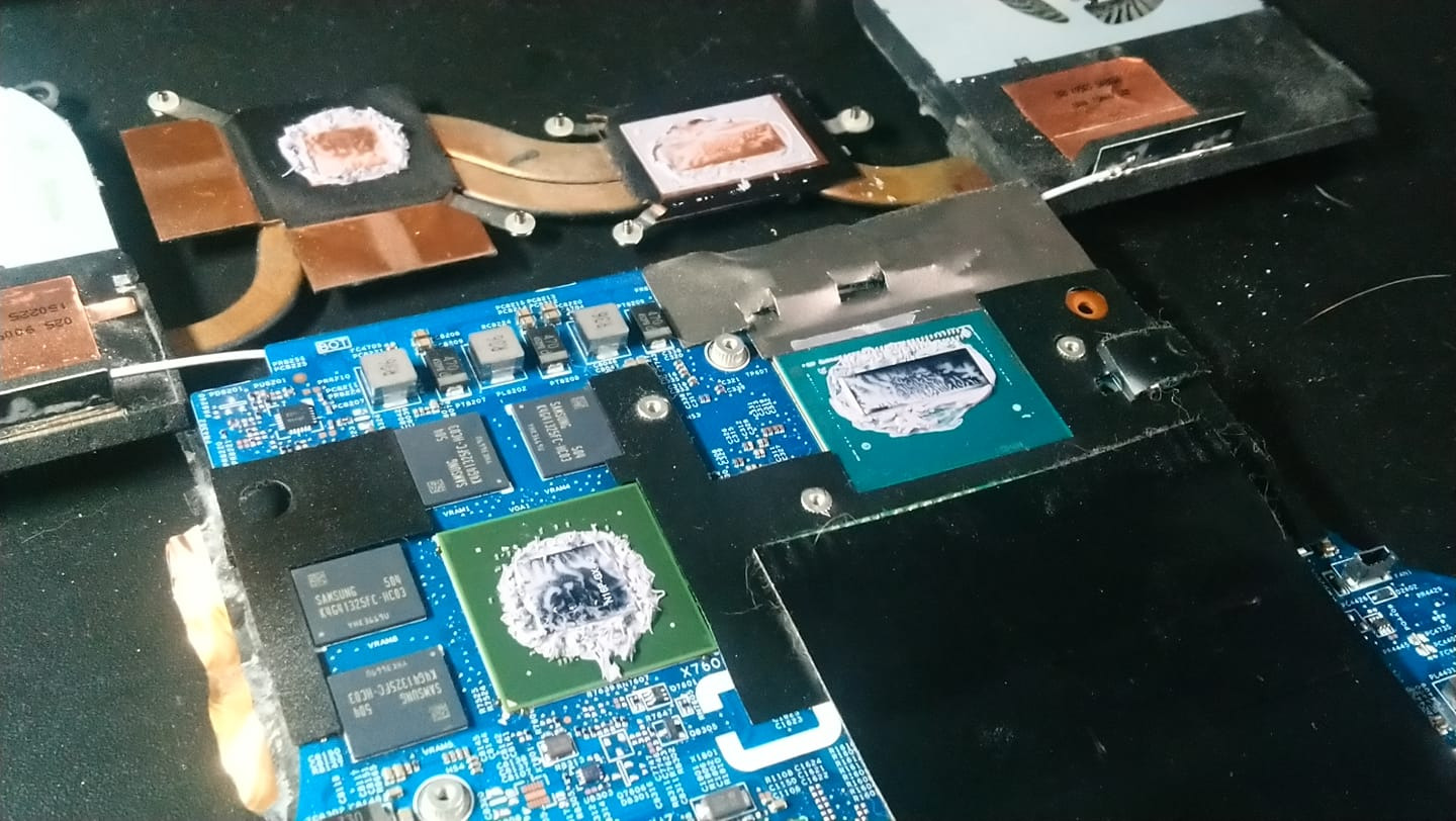 Otwarta obudowa laptopa z widoczną płytą główną, procesorami pokrytymi świeżą pastą termoprzewodzącą i elementami układu chłodzenia. Widoczne moduły pamięci Samsung.