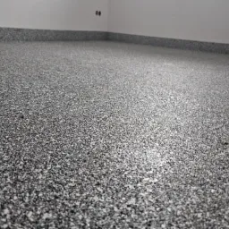 Szara, drobnoziarnista posadzka w pomieszczeniu w Otwocku, z widocznymi gniazdkami elektrycznymi przy ścianie, wykonana z bliska.