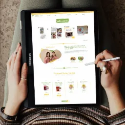 Osoba używa rysika do nawigacji po stronie internetowej sklepu internetowego na tablecie Samsung, prezentującego ofertę produktów dla kobiet planujących ciążę, z przyjaznym designem i jasną...