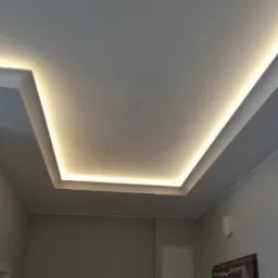 Podwieszany sufit z oświetleniem LED wzdłuż krawędzi, tworzący efektowną ramę świetlną w pomieszczeniu.