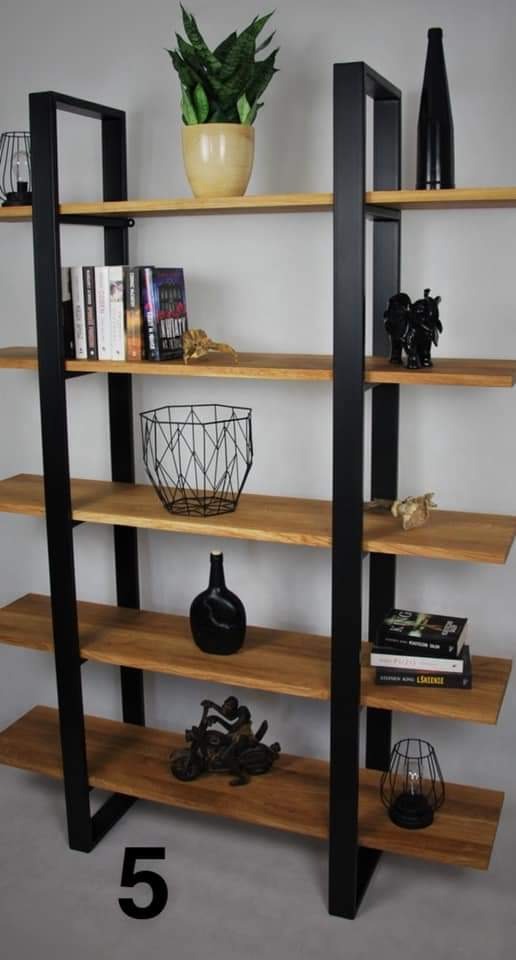 Ręcznie robiony regał z drewnianymi półkami i czarną metalową ramą, eksponujący dekoracje i książki na tle szarej ściany.