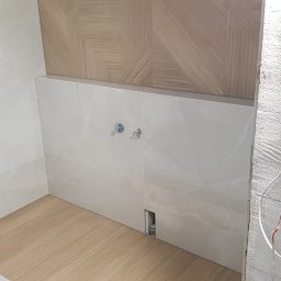 Realizacja łazienki w miejscowości Łochowo. Prace na podstawie projektu.  Kafle 120/60. Część ściany wysunięta przez co uzyskano wnękę na podświetlenie ledowe. Pomieszczenie przygotowane do białego montażu.