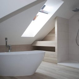 Profesjonalne wykańczanie wnętrz - Nowoczesna łazienka na poddaszu ze skośnym sufitem, wolnostojąca wanna owalna, prysznic typu walk-in z deszczownicą i płytki w odcieniach beżu i bieli