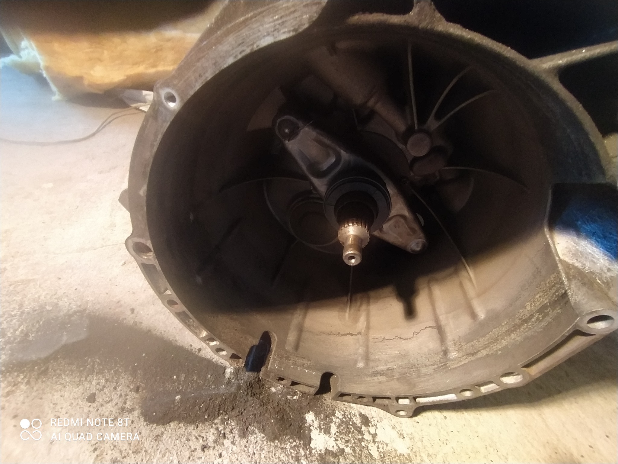 Wnętrze obudowy skrzyni biegów z widocznym elementem sprzęgła i zabrudzeniami na zewnątrz