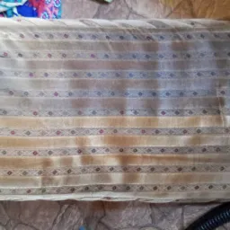 Fragment tapicerki krzesła z widocznymi plamami przed czyszczeniem, obok widoczny fragment odkurzacza piorącego.