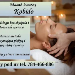 Kobieta podczas masażu twarzy Kobido, dłonie terapeuty delikatnie dotykają jej skroni, w tle rozmyte światło świec.