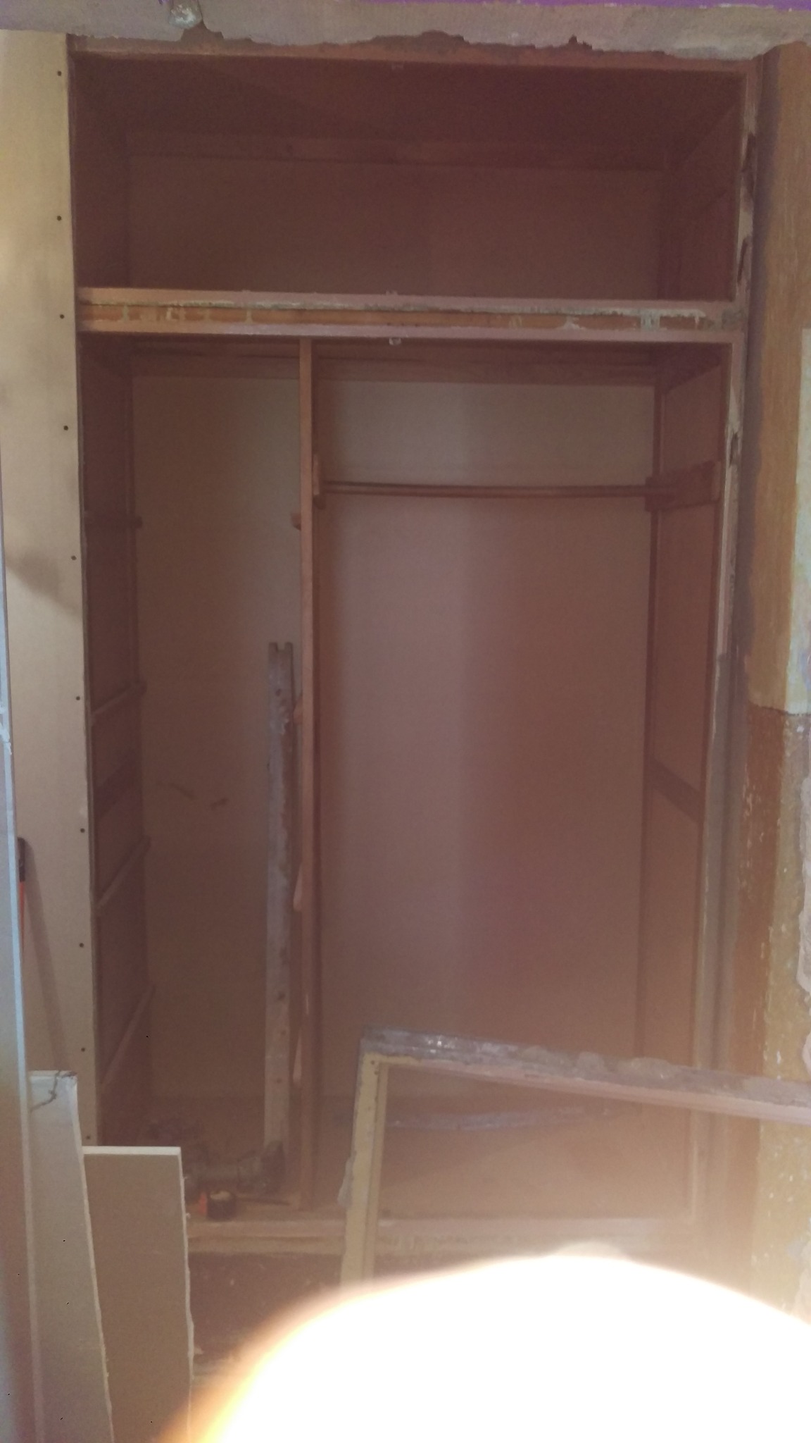 Wnętrze szafy wnękowej w trakcie demontażu, widoczne surowe ściany i fragmenty konstrukcji, przygotowane do dalszych prac wykończeniowych.