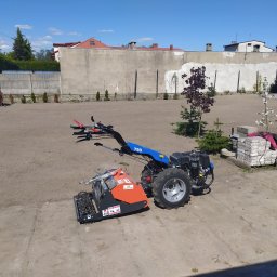 Kena - Glebogryzarka separacyjna Muratori MZ3 na betonowej nawierzchni, przygotowana do wyrównania terenu pod trawnik, w tle młode drzewka i betonowy płot.