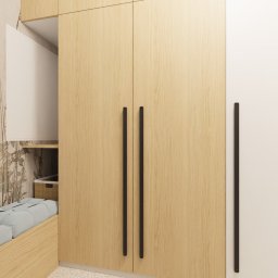 Studio Sto - Wnętrze sypialni z łóżkiem w zabudowie, tapetą w motywy roślinne i wysoką, drewnianą szafą z czarnymi uchwytami, widok na jadalnię w tle.