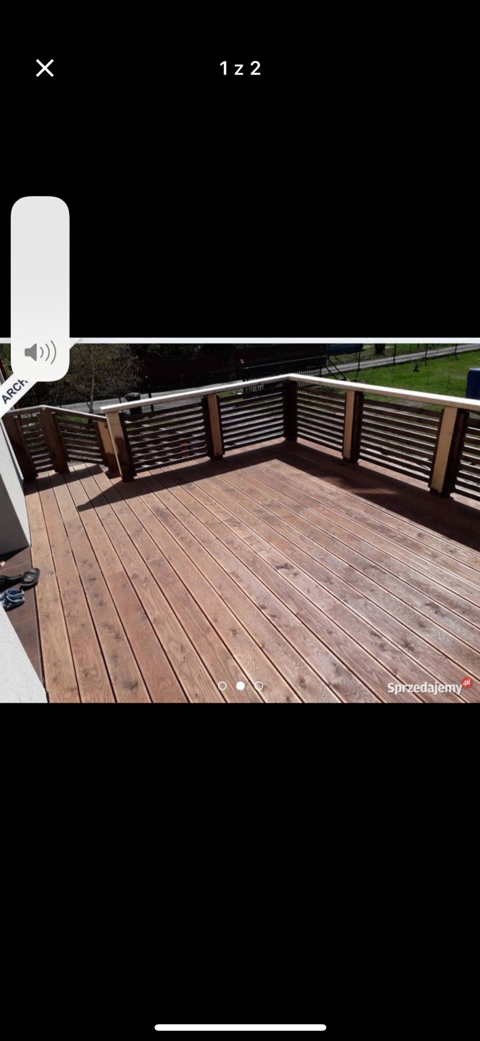 Drewniany taras z brązowymi deskami i jasnymi barierkami, widok z góry na ukończoną konstrukcję.