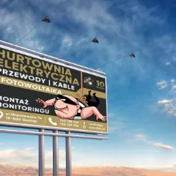 Billboard reklamujący hurtownię elektryczną z zabawną ilustracją złodzieja wiszącego na linie, na tle pustynnego krajobrazu i błękitnego nieba z chmurami.