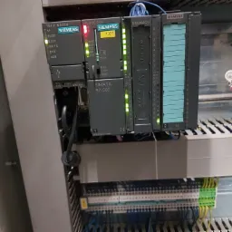 Panel sterowania Siemens Simatic S7-300 z modułami CPU, modemem i wejściami/wyjściami cyfrowymi, widoczne diody LED sygnalizujące status pracy.