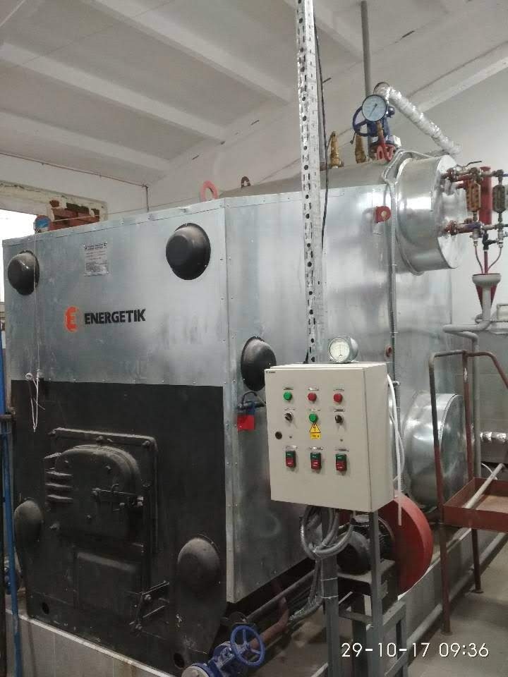 Kocioł przemysłowy marki Energetik z panelem sterowania, manometrem i rurami, w pomieszczeniu kotłowni z widoczną datą wykonania zdjęcia.