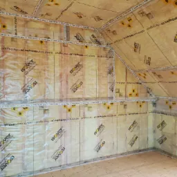 Poddasze z widoczną izolacją z folii paroizolacyjnej Isover Vario KM Duplex UV, zabezpieczoną taśmami uszczelniającymi Isover Vario KB1, gotowe do montażu płyt kartonowo-gipsowych.