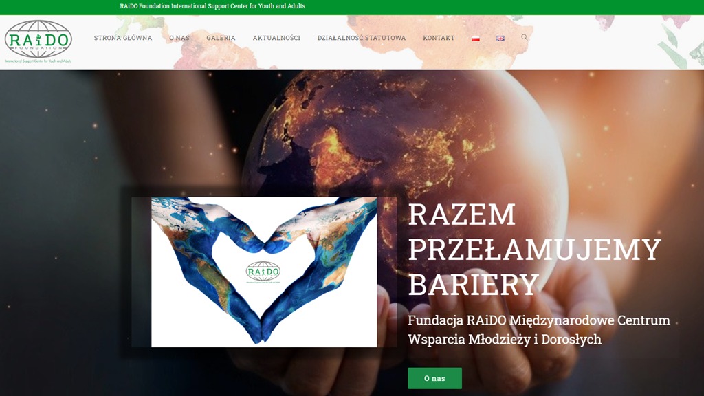 Strona internetowa fundacji RAIDO z grafiką dłoni ułożonych w kształt serca z mapą świata i hasłem 'Razem przełamujemy bariery'.