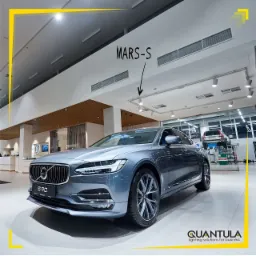 Salon samochodowy Volvo S90 z oświetleniem sufitowym typu MARS-S od Quantula, widoczny podnośnik samochodowy w tle.
