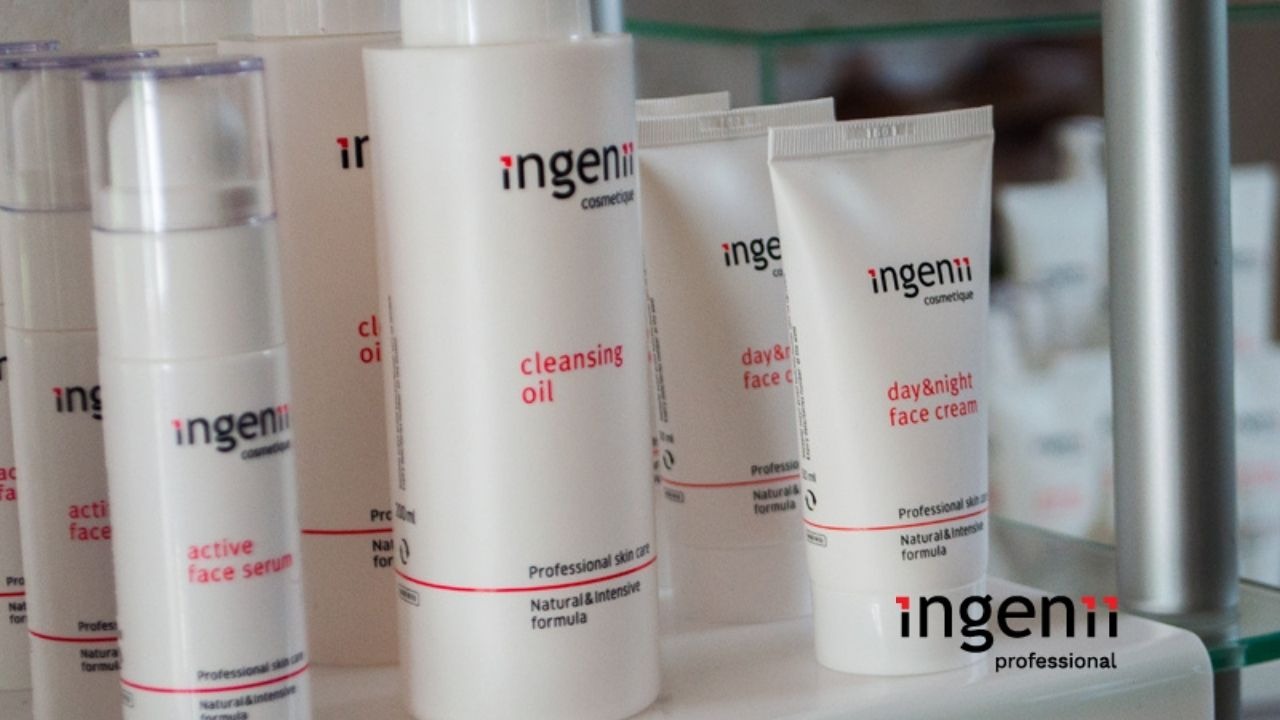 Różne produkty kosmetyczne marki Ingenii: serum do twarzy, olejek oczyszczający oraz krem do twarzy na dzień i na noc, ustawione na szklanej półce.