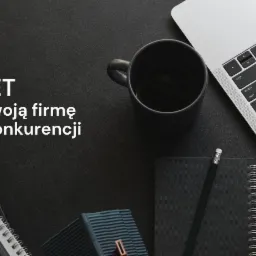 Minimalistyczne biurko z laptopem, czarnym kubkiem, notatnikami, ołówkiem i dekoracyjną wazą na ciemnym tle, z tekstem 'KD-NET Wybij swoją firmę wśród konkurencji'.