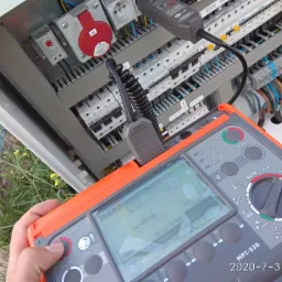 Pomiar elektryczny rozdzielnicy za pomocą miernika MPI-530 z widocznym ekranem wskazującym czas wyłączenia tA=8ms, na tle zieleni