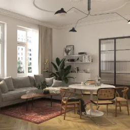 Jasne wnętrze salonu z szarą sofą, okrągłym stołem i drewnianymi krzesłami w stylu vintage, oświetlone lampą sufitową z trzema kloszami i naturalnym światłem z dużych okien.