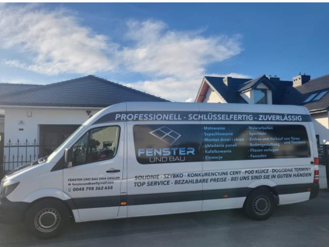 Biały samochód dostawczy firmy budowlanej 'Fenster und Bau' z listą oferowanych usług (montaż okien, elewacje, malowanie) zaparkowany na tle domu jednorodzinnego z ciemnym dachem.