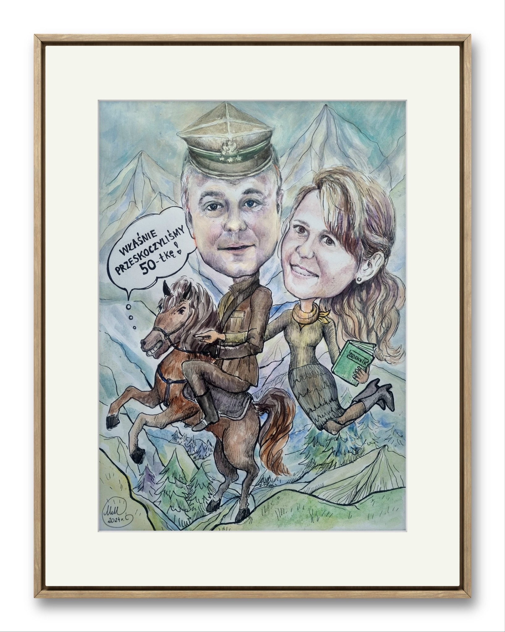 Karykatura akwarelowa w ramie przedstawiająca parę: mężczyzna w mundurze na koniu, kobieta trzymająca zielony dziennik, oboje z dużymi głowami na tle gór, z dymkiem z napisem 'Właśnie...