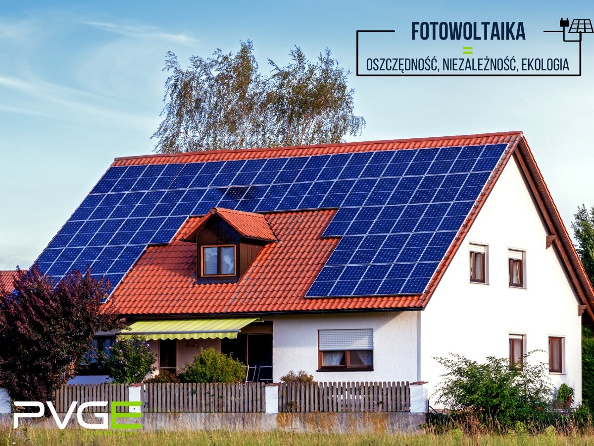 Dom jednorodzinny z czerwoną dachówką i panelami słonecznymi na dachu, widok z poziomu gruntu, w tle drzewa i błękitne niebo.