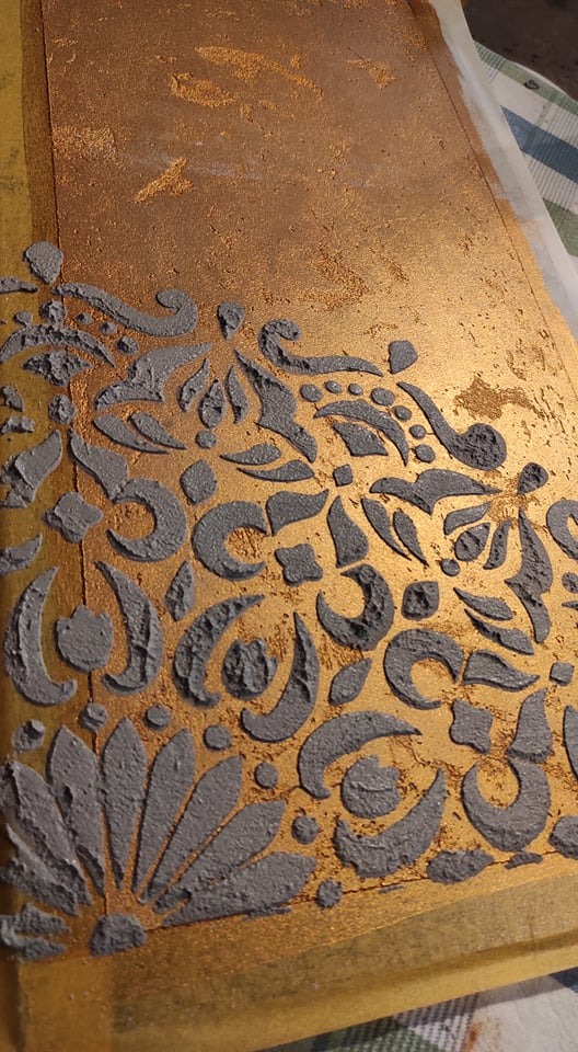 Dekoracyjna ściana w Kętach z efektem złota i szarym, wypukłym wzorem roślinnym.