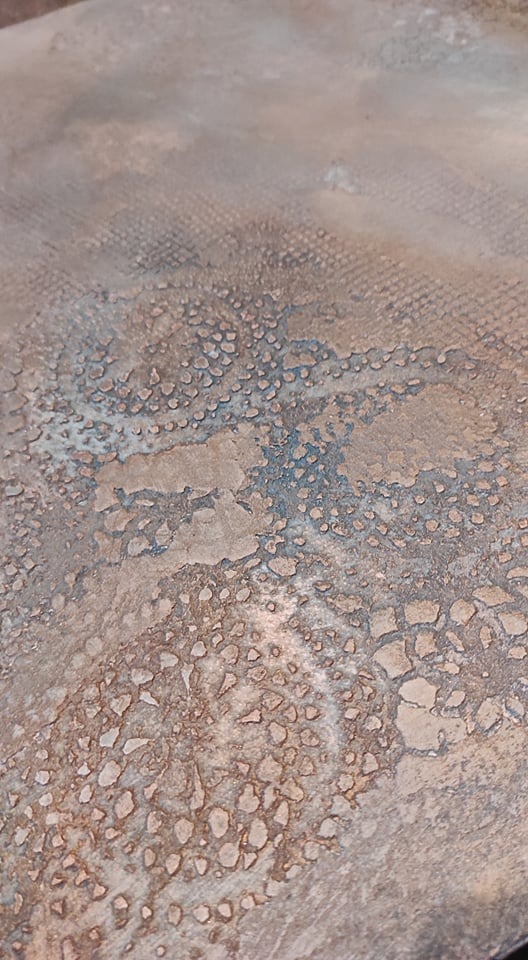 Zbliżenie na fakturę ściany z efektem dekoracyjnym imitującym spękania i przebarwienia w odcieniach beżu i błękitu.