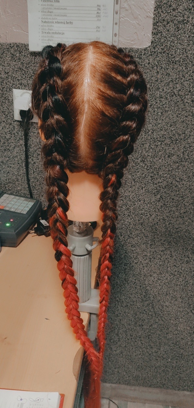 Brązowe włosy zaplecione w dwa warkocze ombre z czerwonymi końcówkami na manekinie fryzjerskim, widok z tyłu.
