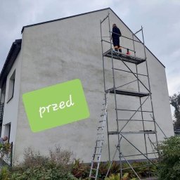 PRAMIX Mariusz Połeć - Dwupiętrowy dom z szarą elewacją przed czyszczeniem, widoczny pracownik na rusztowaniu i zielony napis 'przed' na elewacji.