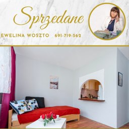 Dzieciogród Ewelina Woszto - Jasne wnętrze mieszkania z łóżkiem i widokiem na kuchnię przez łuk. U góry napis 'Sprzedane' i dane kontaktowe agenta Eweliny Woszto.