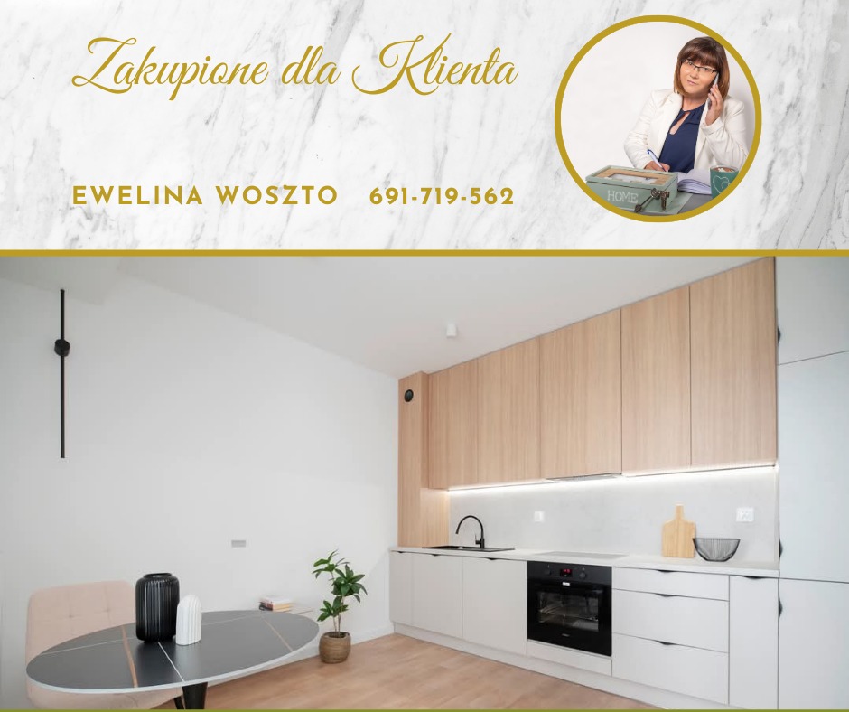 Jasna kuchnia z drewnianymi szafkami i czarnymi akcentami, stół z dekoracjami, w tle zdjęcie agentki nieruchomości Eweliny Woszto z numerem telefonu.