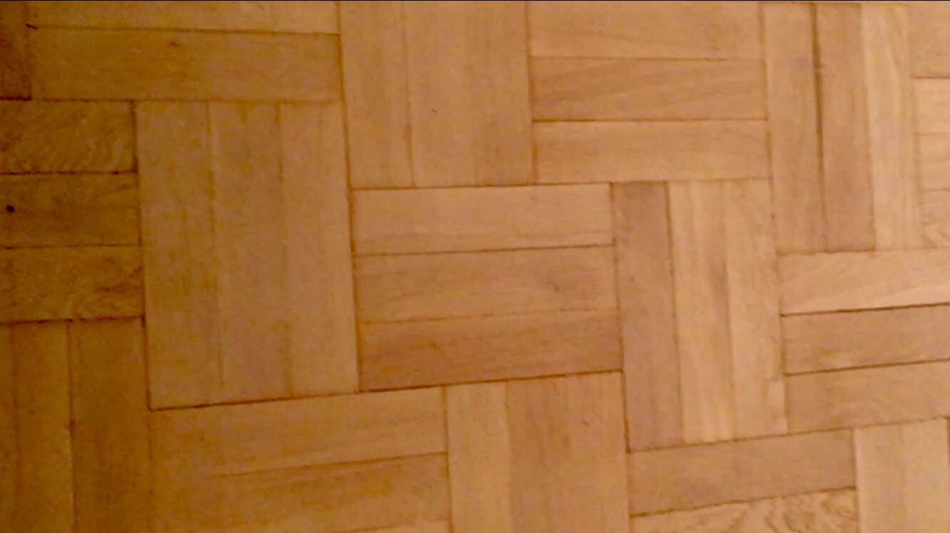 Parkiet ułożony we wzór jodełki, świeżo po cyklinowaniu, ukazujący naturalne usłojenie drewna i subtelne różnice w odcieniach poszczególnych klepek.