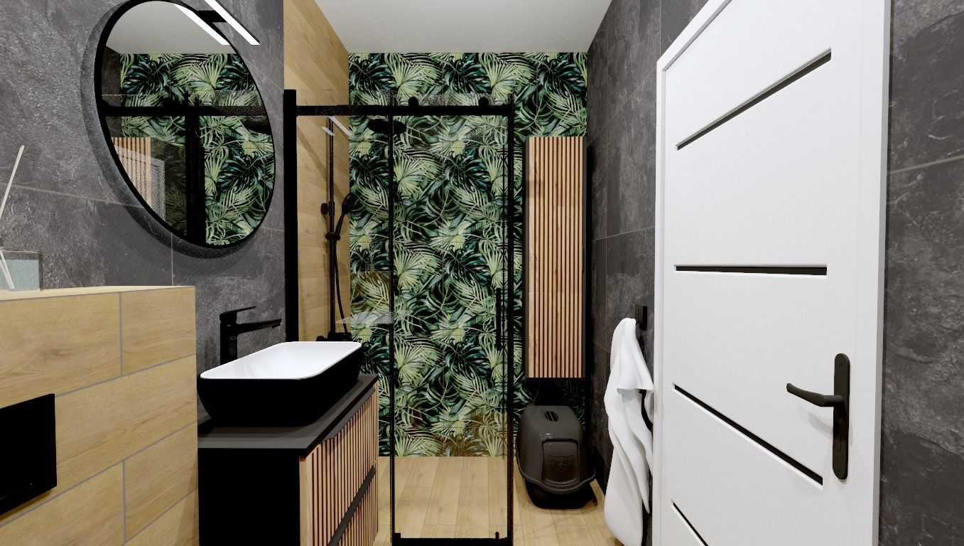 Nowoczesna łazienka z czarną umywalką nablatową, okrągłym lustrem z podświetleniem i kabiną prysznicową z motywem tropikalnych liści na ścianie, uzupełniona o białą szafkę i drewniane akcenty.