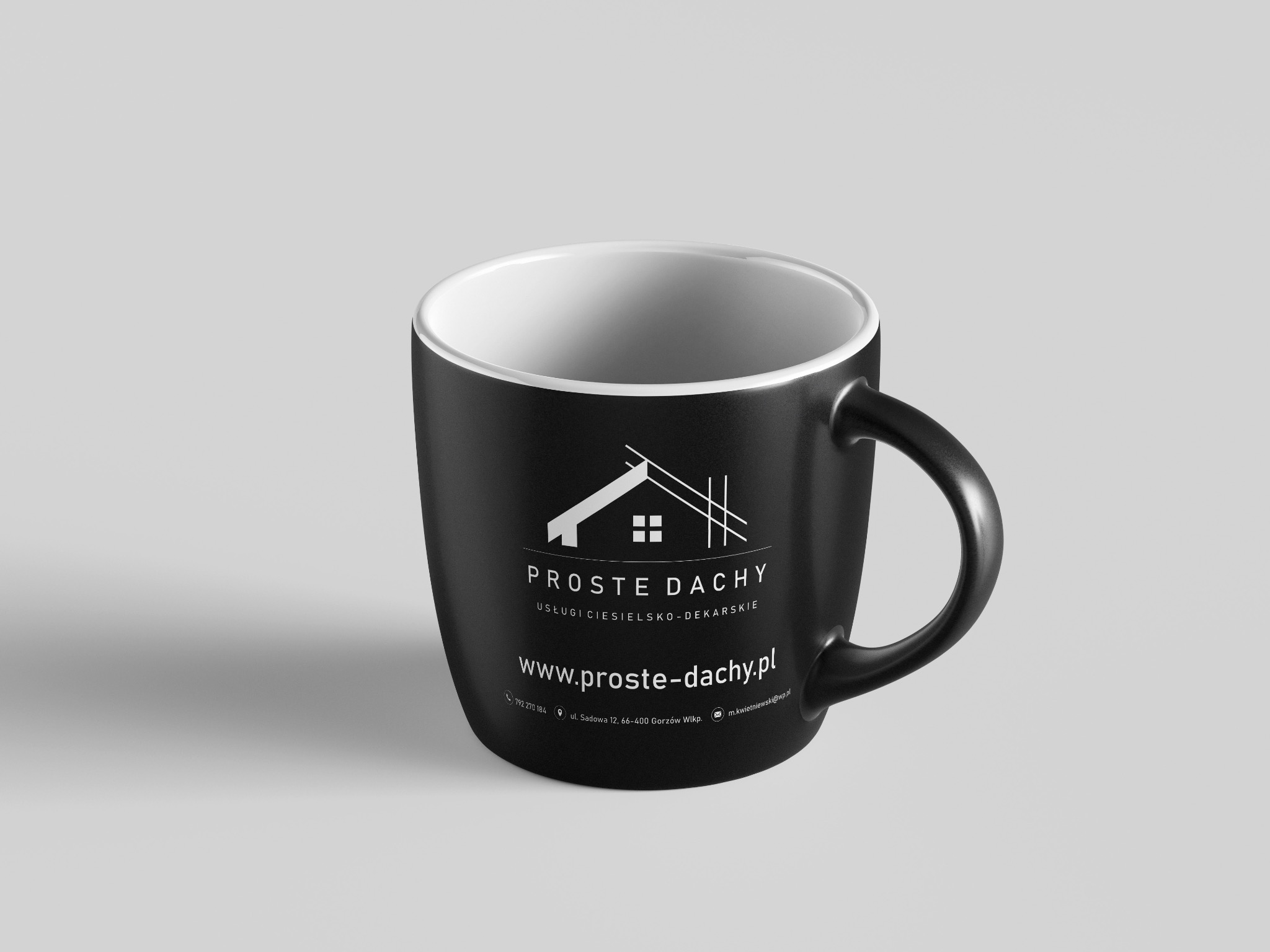Czarny kubek z logo firmy dekarskiej 'Proste Dachy', prezentujący usługi ciesielsko-dekarskie i dane kontaktowe, umieszczony na jasnym tle. Minimalistyczny design.