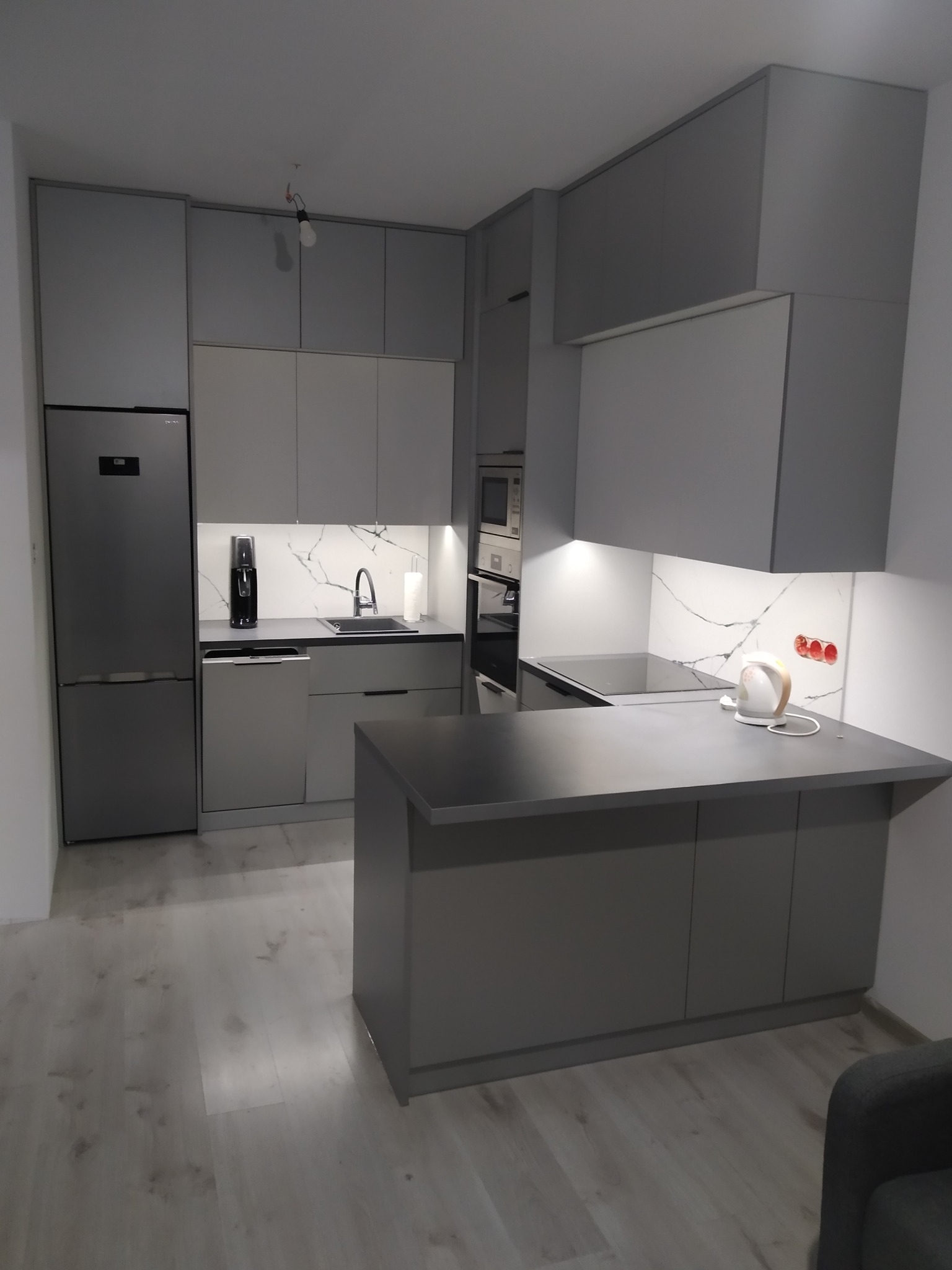 Zabudowa małego aneksu kuchennego z podswietlanymi szufladami