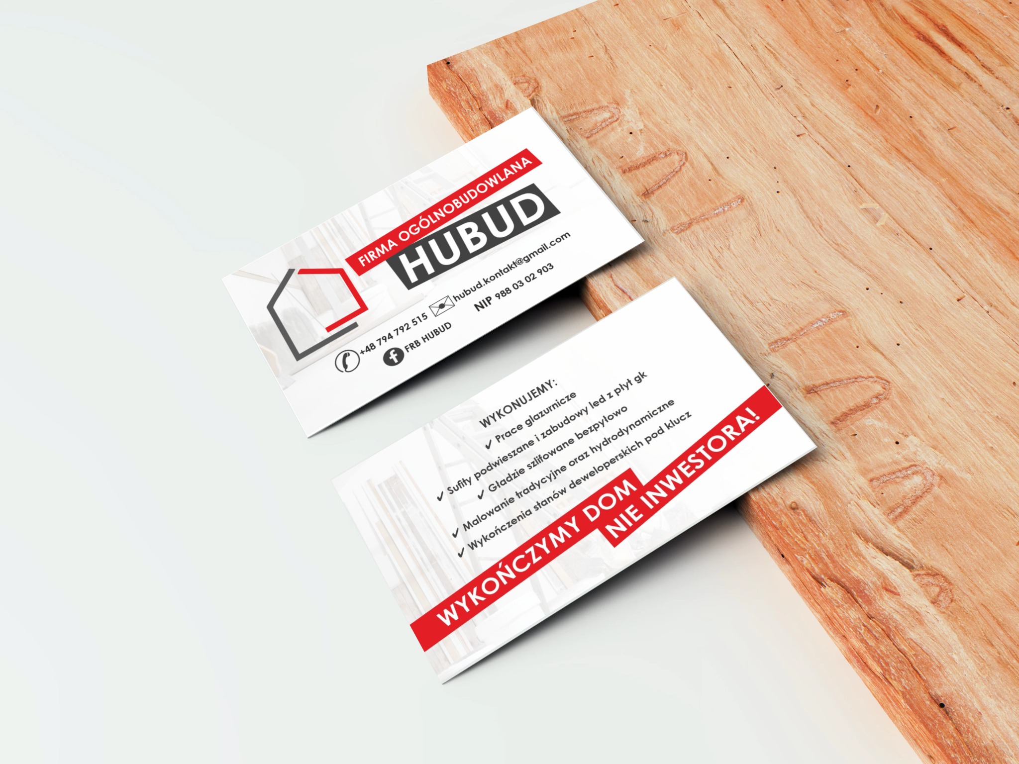 Dwie wizytówki firmy ogólnobudowlanej Hubud leżące na drewnianym blacie, prezentujące logo, dane kontaktowe oraz zakres usług.