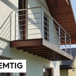 Balkon z nowoczesną, stalową barierką z poziomymi szczeblami w Imielinie, zamontowany na drewnianej konstrukcji, rzucający cienie na jasną elewację budynku.