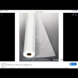 Rolka białej flizeliny budowlanej z włókna szklanego, przeznaczona do wzmacniania ścian ze spękaniami, widoczna na neutralnym tle.