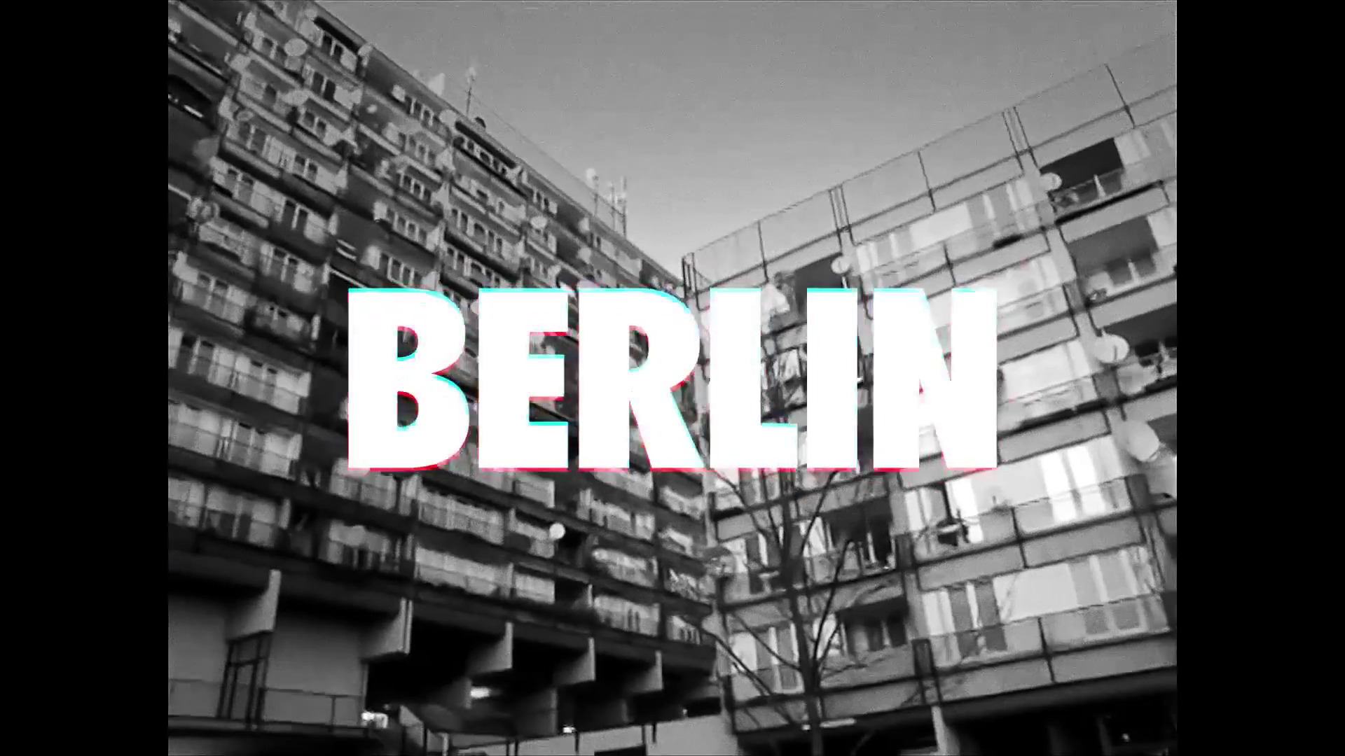 Czarno-białe ujęcie bloków mieszkalnych w Berlinie z nałożonym tekstem 'BERLIN' z efektem glitch.