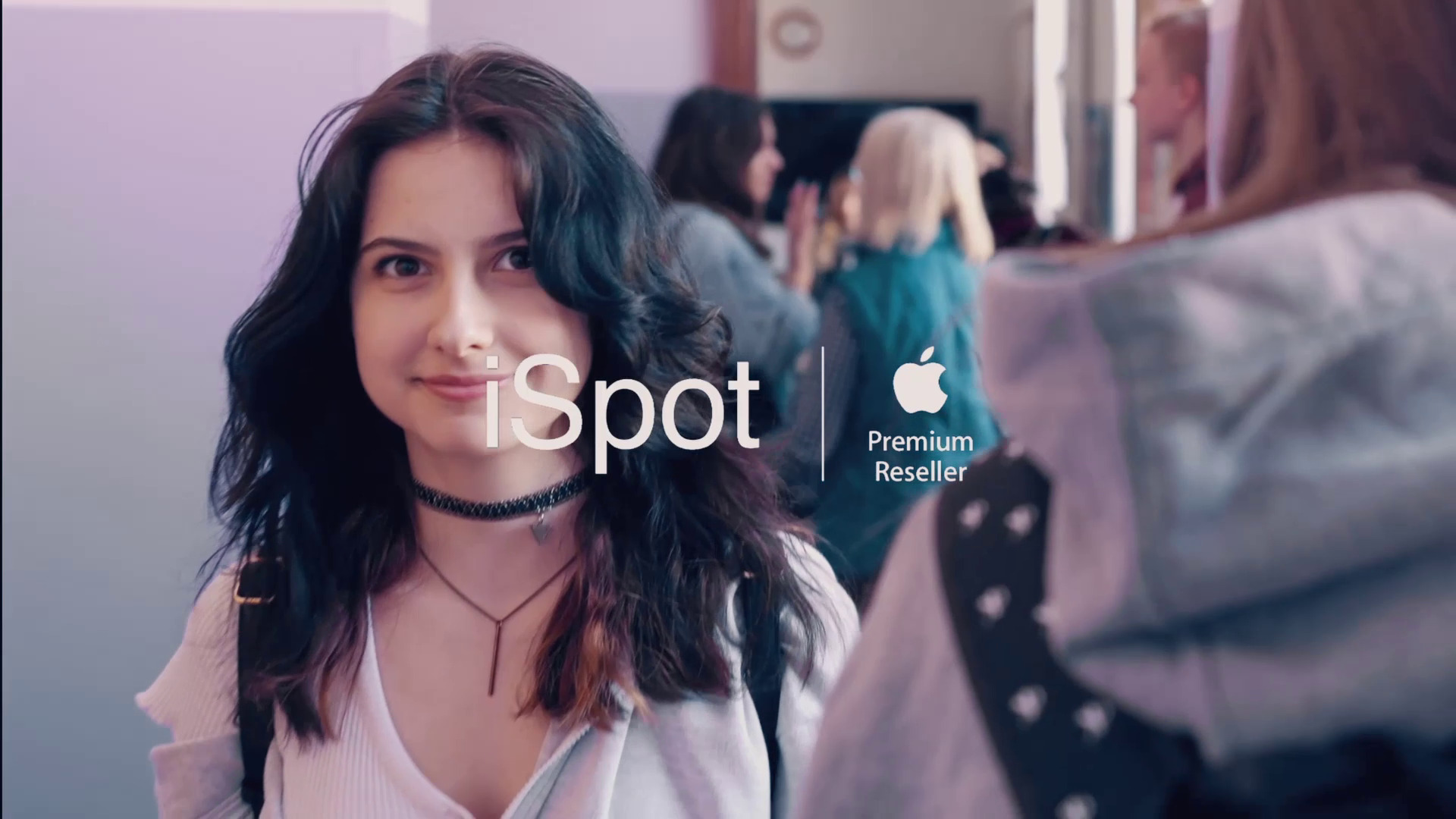 Portret młodej kobiety z ciemnymi włosami i chokerem, na pierwszym planie logo iSpot Premium Reseller, w tle osoby w przestrzeni publicznej.