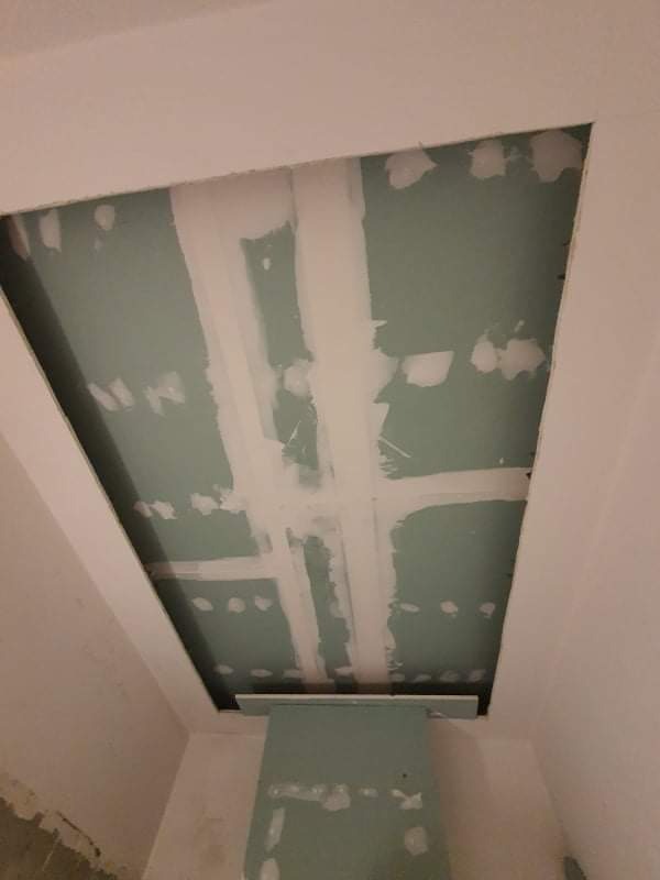 Montaż płyty karton gips na suficie w Szczecinie, widoczne łączenia wzmocnione taśmą i częściowo zaszpachlowane, sufit przygotowywany do dalszych prac wykończeniowych.