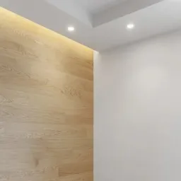 Ściana wykończona jasnymi panelami drewnopodobnymi z subtelnym oświetleniem LED u góry, sąsiadująca z gładką, białą ścianą i dwoma punktowymi lampami sufitowymi.