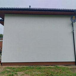 Usługi budowlane, Tomasz Wochnik, Henryk Wochnik - Świeżo otynkowana ściana budynku z zamontowaną anteną satelitarną Polsat Box, widoczne ślady prac budowlanych w tle.