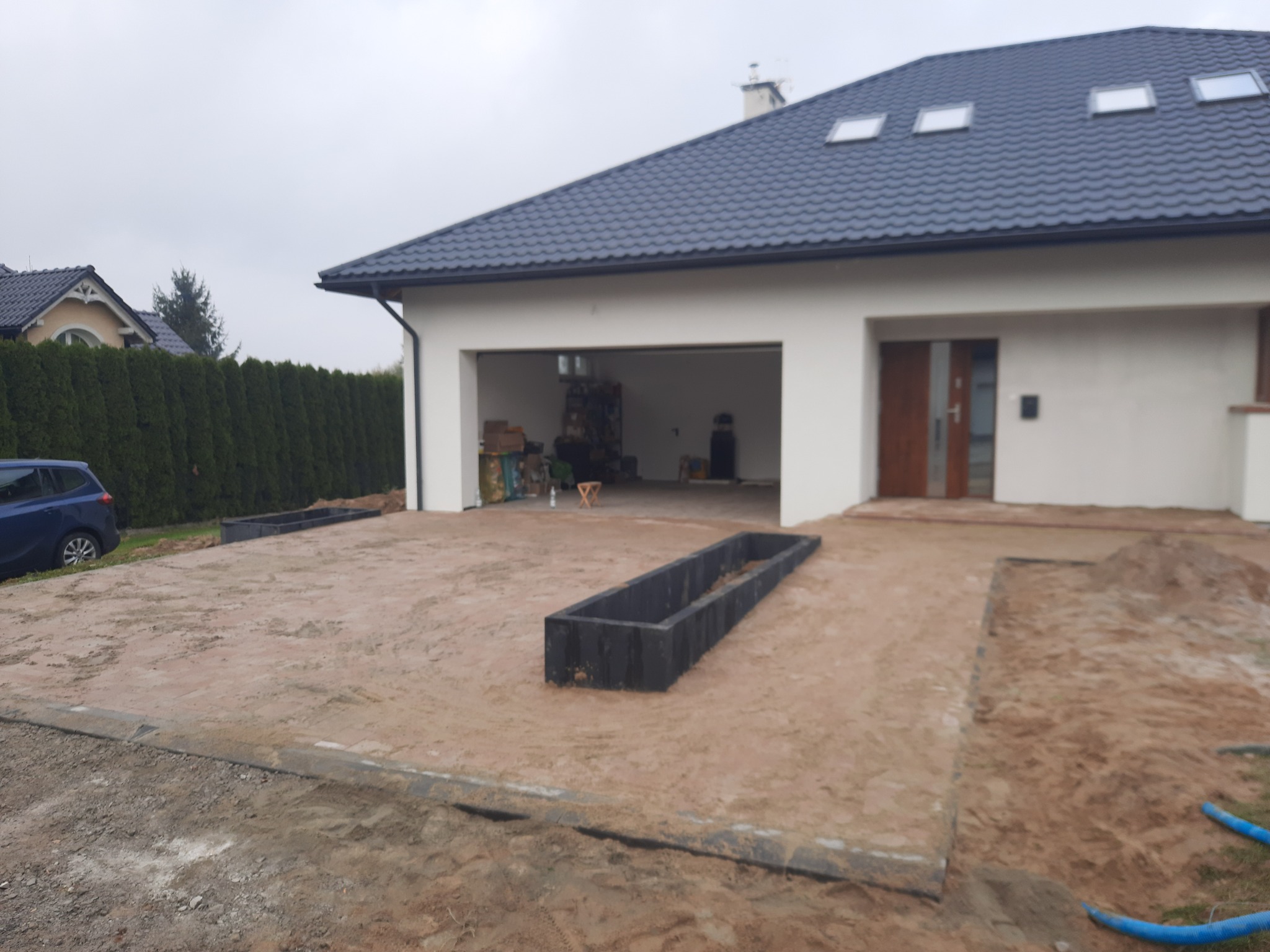 Przygotowanie podłoża pod kostkę brukową przed domem w Przeworsku, widoczne obrzeża i piasek.